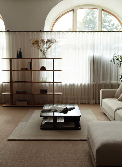 Vaalea Geo One villamatto osana vaaleaa olohuoneen sisustusta. Taustalla vaaleat valoverhot ja tamminen kirjahylly. 