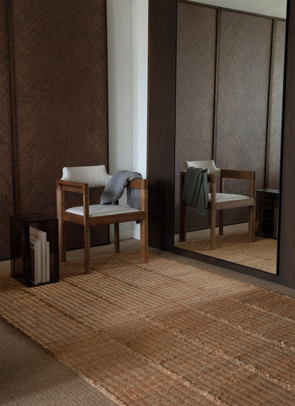 Waffle Line -hamppumattoon heijastuu valoa suuren peilin kautta. Peilistä heijastuu myös maton päällä oleva puinen tuoli.